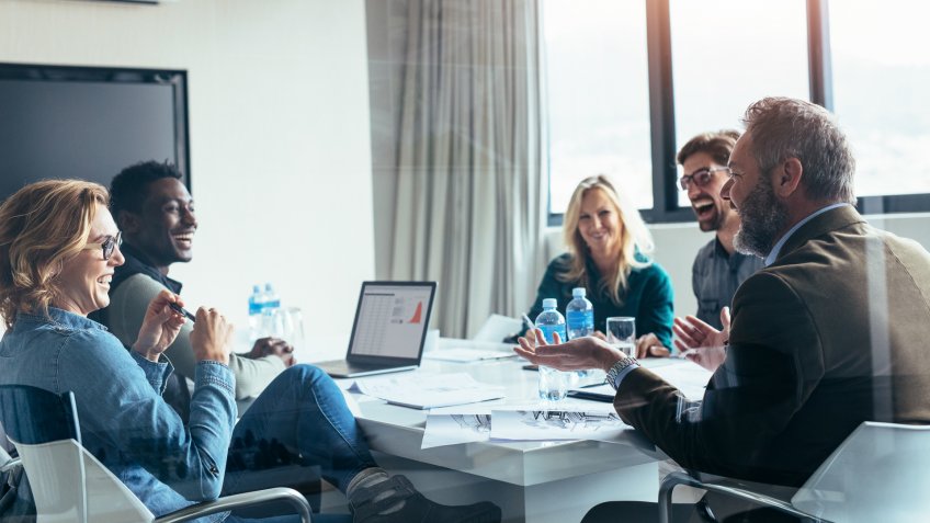 Business people having casual discussion during meeting in board room.