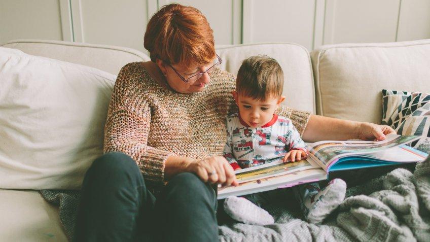 grandparent with child reading book.