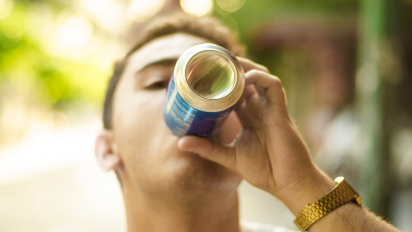A boy drinking a beverage can.