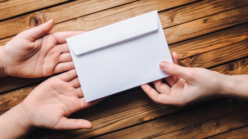 handing over an envelope of donations