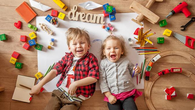 Kids drawing on floor on paper.