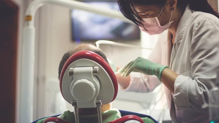 Dentist examines the teeth of patient.