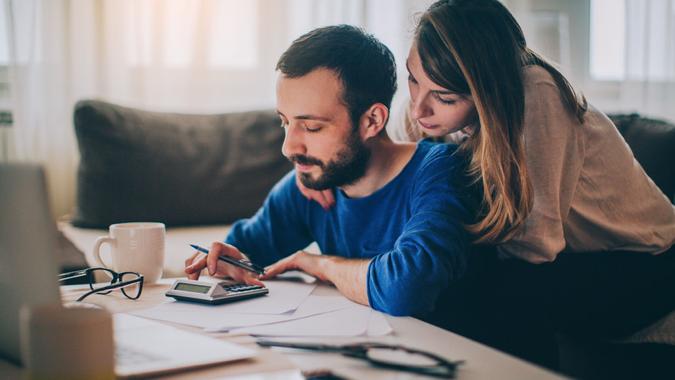 Couple sitting in their living room and checking their finances.