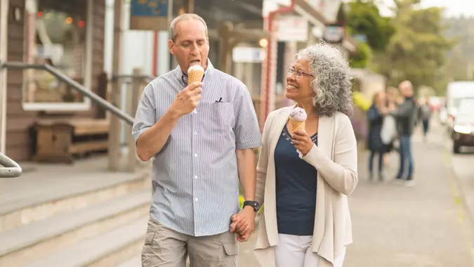 A senior couple enjoy a walk together and ice cream cones on a lovely summer afternoon.