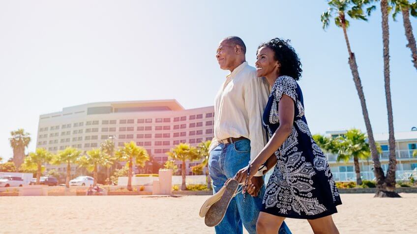 African mature couple in love walking on the beach.