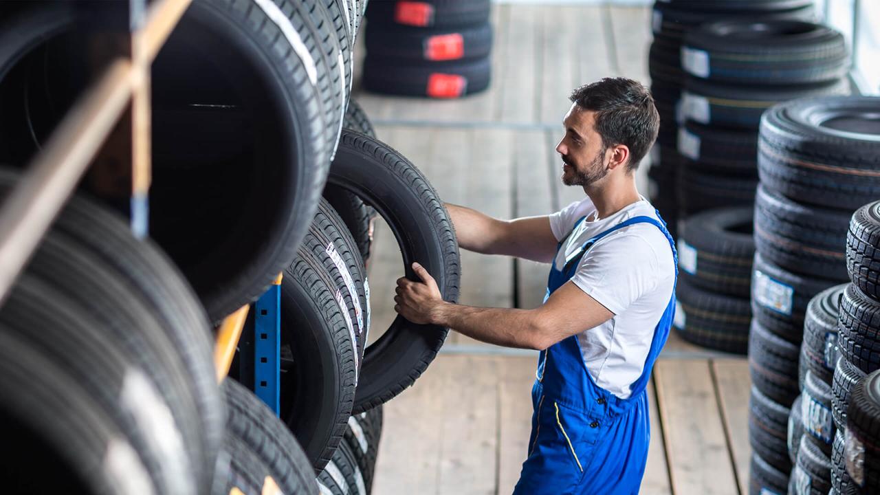 Auto mechanic  choose tire for car at a tire store.