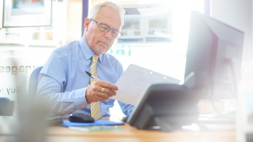Mature businessman in office environment working at his desk.
