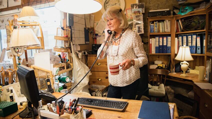 Senior woman working, talking on the phone.