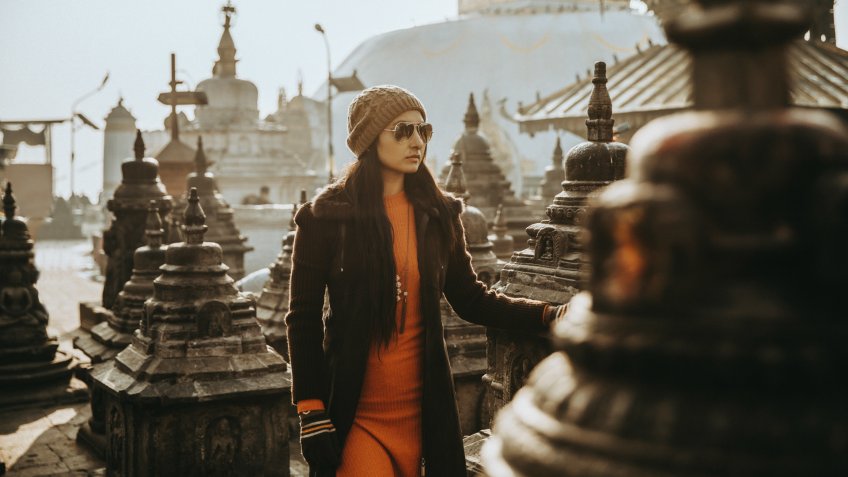 Beautiful young women standing at Nepal temple in winter wear.