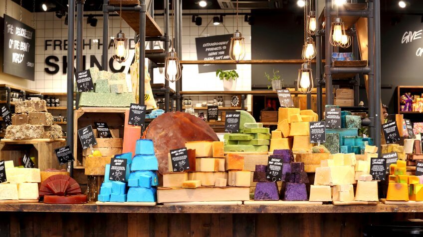 Lush Fresh Handmade Cosmetic’s organic,colorful soap bars on display, selling natural hair and beauty products.