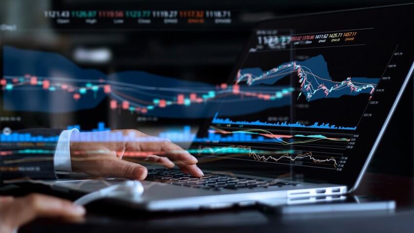 Businessman with statistic graph of stock market financial indices analysis on laptop screen, finance data and technology concept.