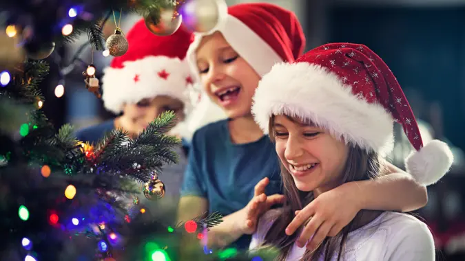 Brothers and sister decorating christmas tree.