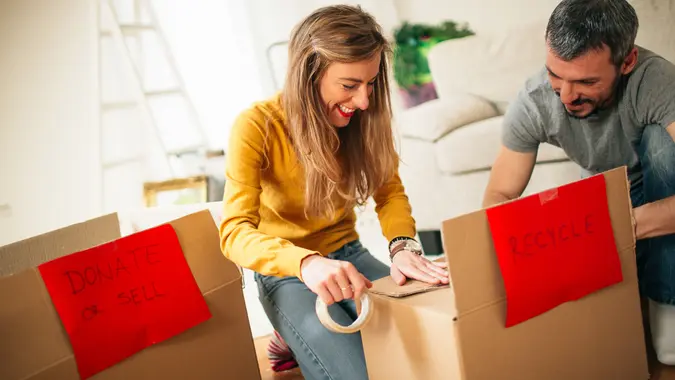 Happy couple packing boxes during the moving process.