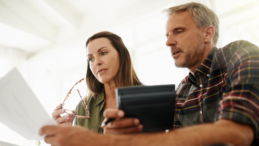 Shot of a mature couple managing their budget together at home.
