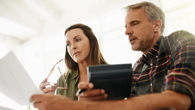 Shot of a mature couple managing their budget together at home.