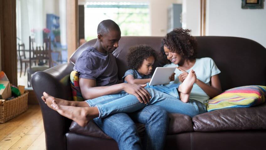 A photo of family sitting on sofa at home.