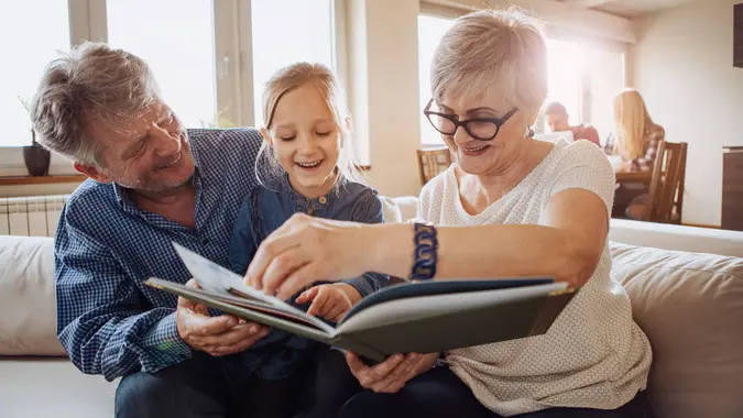 Grandparents having fun and reading stories to little girl.
