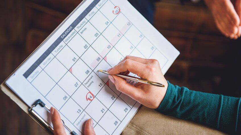 Close up of arms of woman holding schedule.