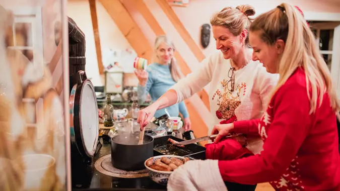 Three women are preparing christmas breakfast in the kitchen at home.