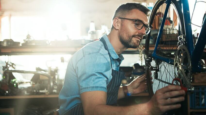 Shot of a mature man working in a bicycle repair shop.