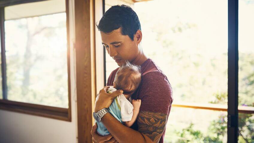 Shot of a young man bonding with his newborn baby boy at home.