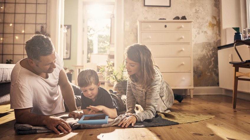 Shot of a little boy and his parents using a digital tablet together at home.