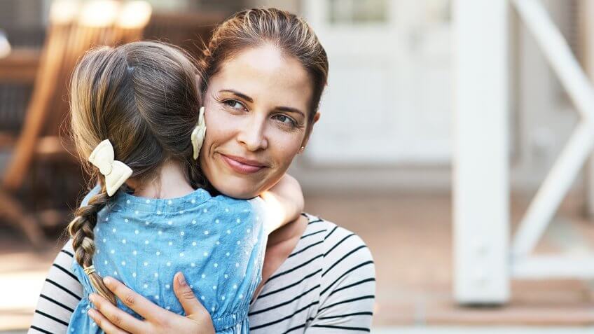Shot of a young woman and her daughter hugging in their backyard.