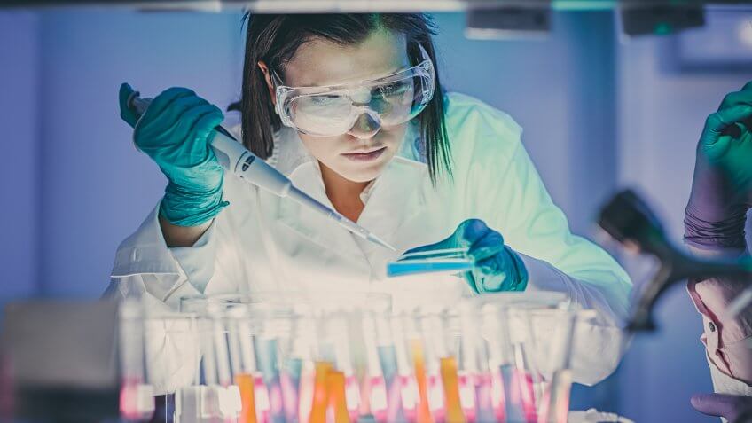 scientist, doctor, asistent working at the laboratory using pipette.