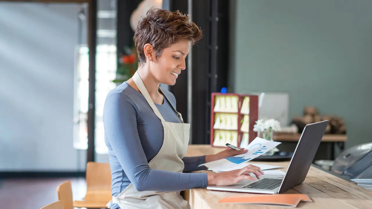 Latin American woman working on his laptop computer at a cafe.