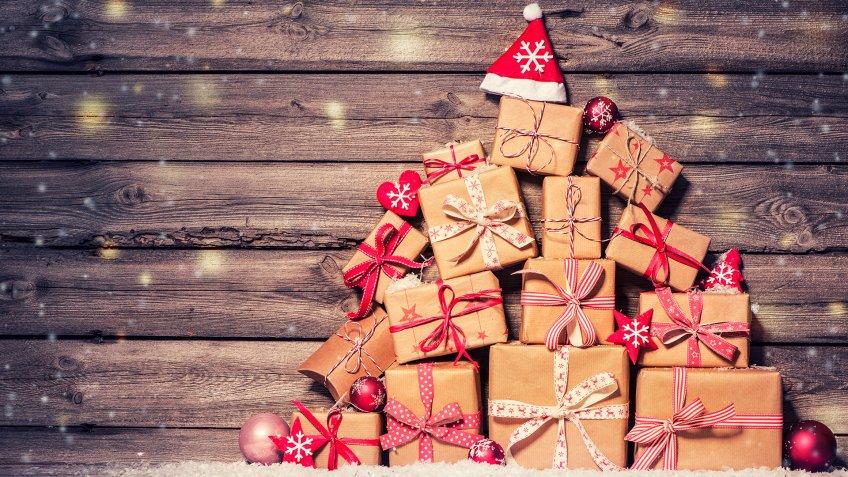 Christmas background with decorations and gift boxes on wooden board.