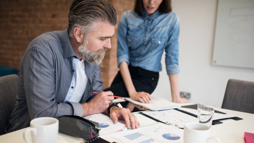 Two business people looking at the last touches and numbers for a project.