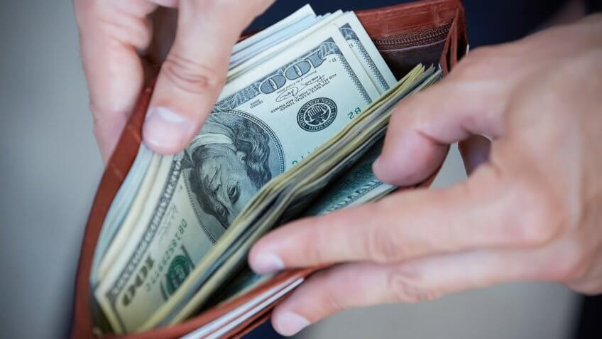 man holding a wallet with money closeup