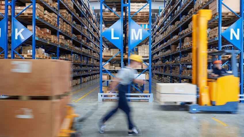 Cardboard boxes on shelves in warehouse.