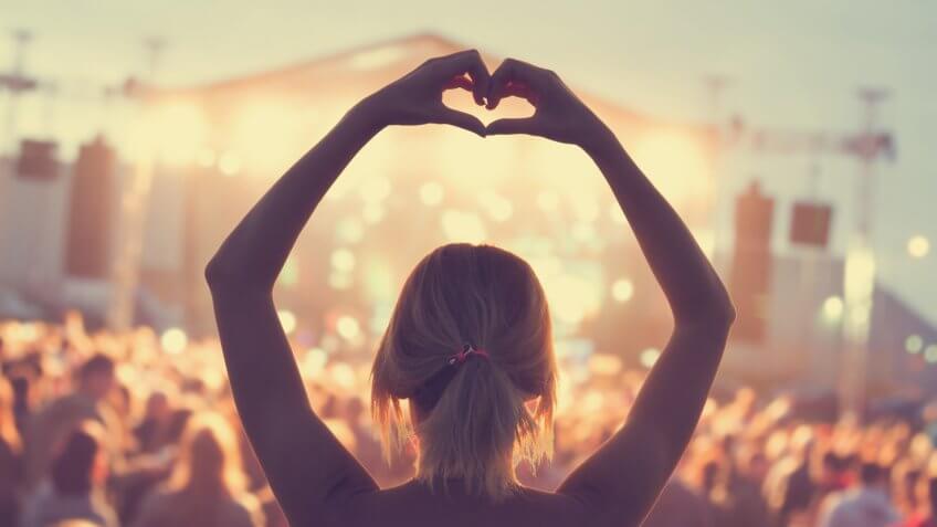 woman at a concert listening to band she loves.