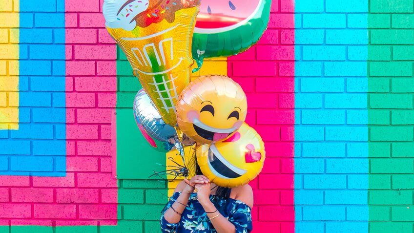 woman holding colorful balloons.