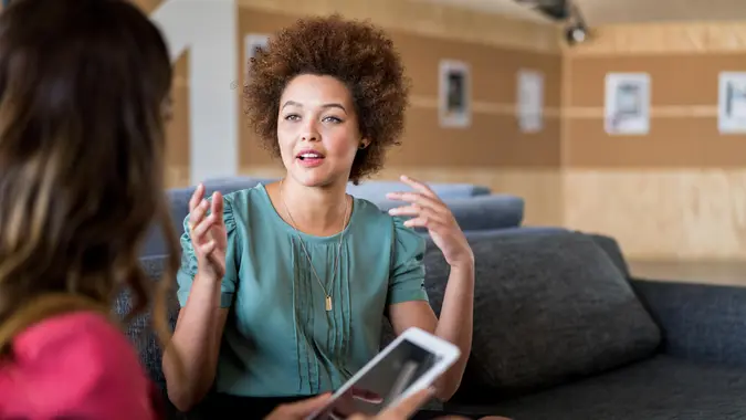 A photo of young businesswoman talking with colleague.