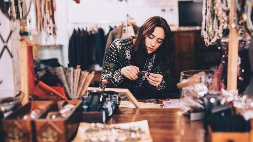 A young woman working on a piece of jewelry.