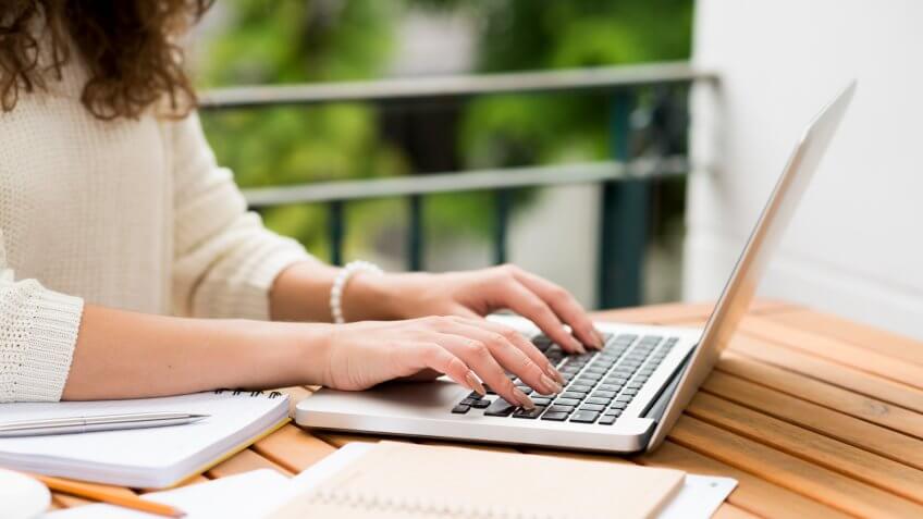 Side view of woman working on laptop, selective focus.