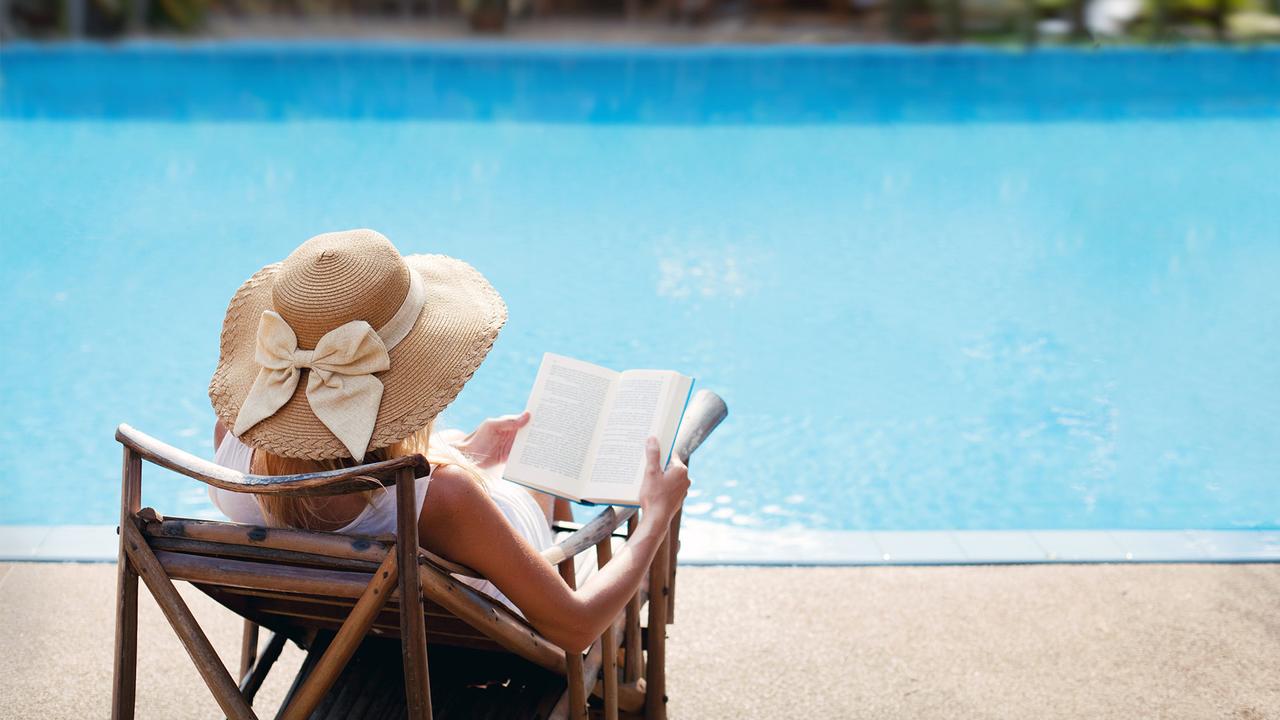 traveler enjoying a book by the pool on vacation