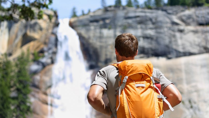 hiking with a backpack up to a waterfall