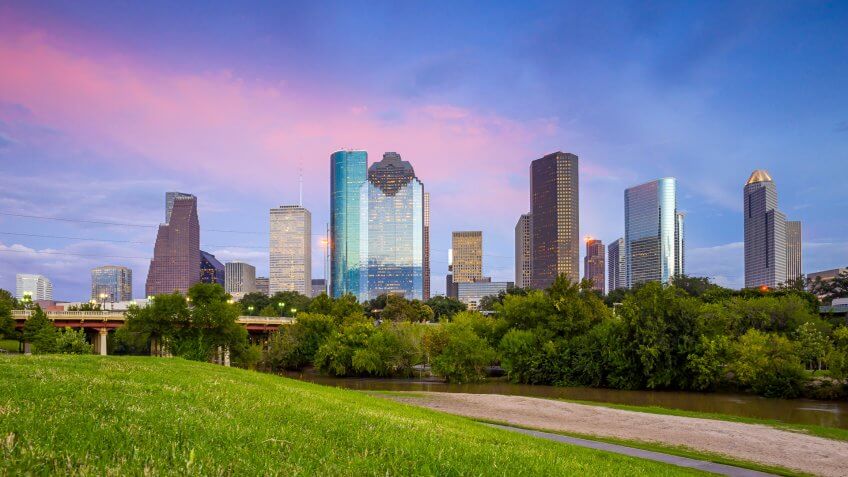 Houston, Texas skyline at sunset twilight from park lawn.