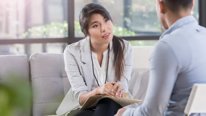 While sitting in a comfortable waiting room, female doctor listens to her patient about mental health problems.