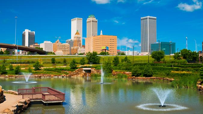 Tulsa skyline with a park, pond, and fountains in the foreground.