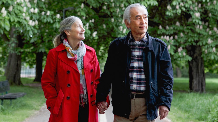 Older couple walking in park