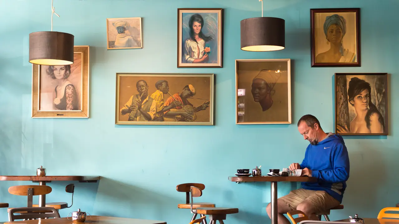 Nelson, New Zealand - February 8th, 2017: A customer is reading a newspaper inside the Kush coffee shop.