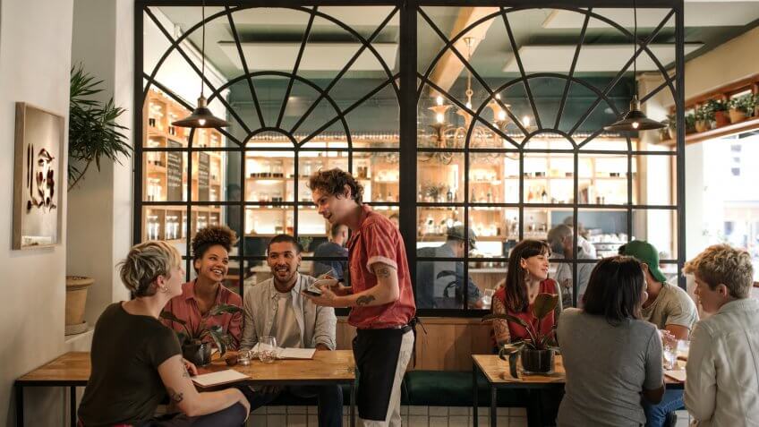 Smiling young waiter taking orders