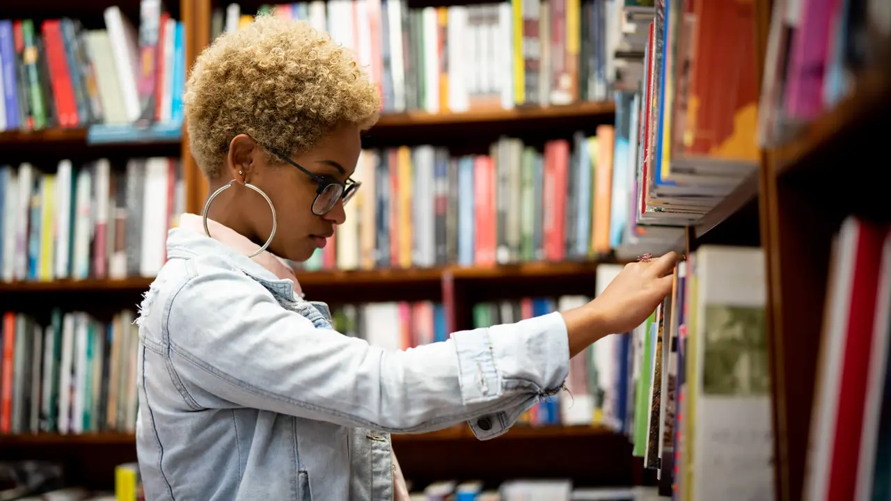 student browsing books in a library bookstore