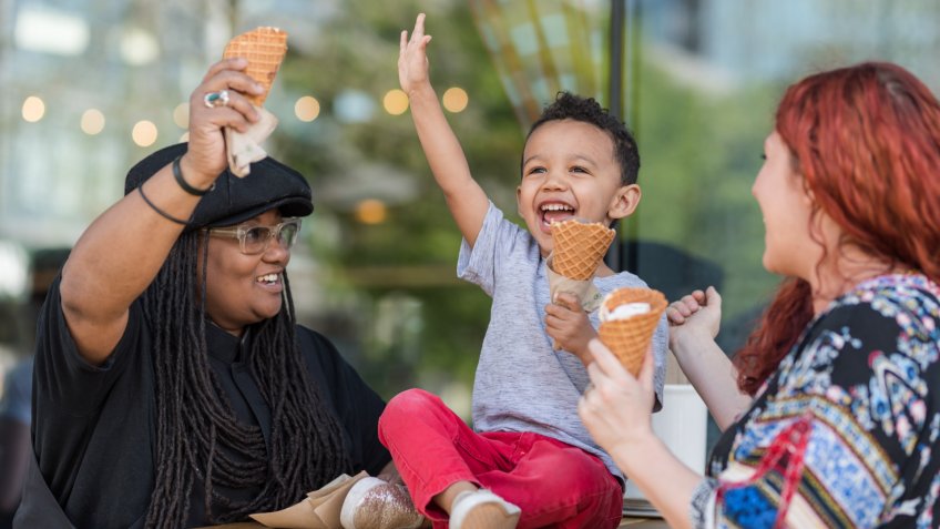 Two moms eat ice cream with their three-year old son