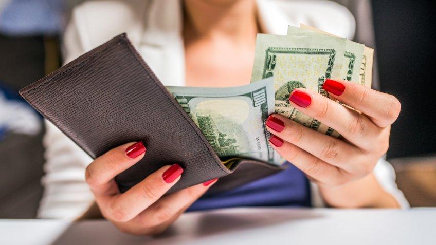 people, business, finances and money concept - close up of businesswoman hands holding open wallet with dollar cash.