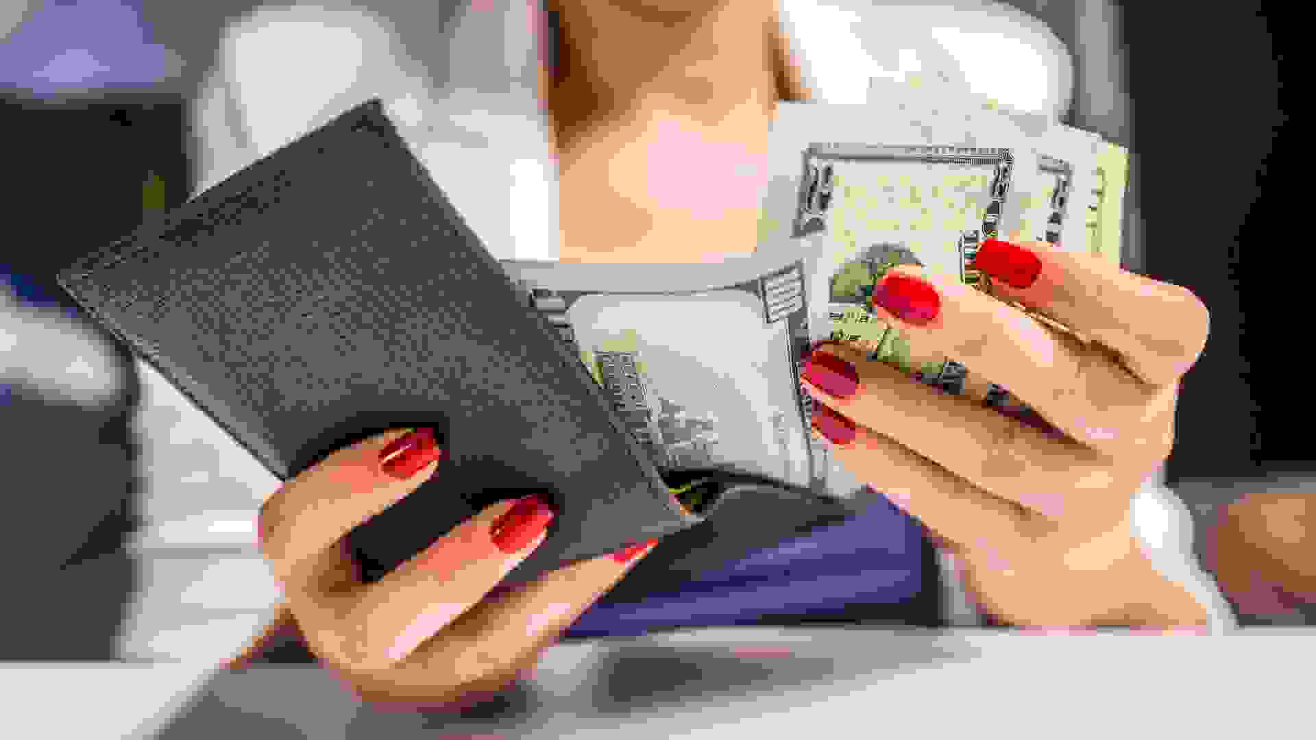 people, business, finances and money concept - close up of businesswoman hands holding open wallet with dollar cash.